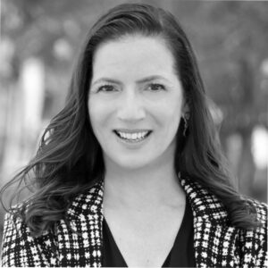 Black and white portrait of a smiling woman with long hair.